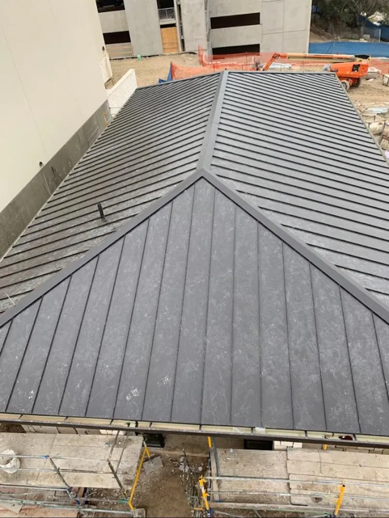 Commercial metal roof construction with crane equipment in Greenwich